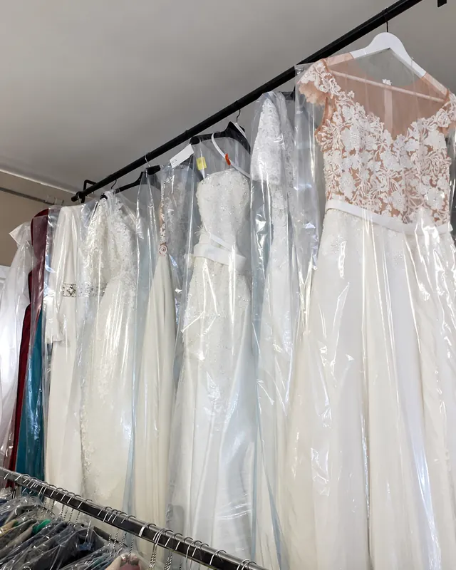 Abiti da sposa protetti dalle custodie, appesi in negozio